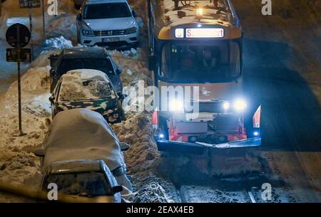 Leipzig, Deutschland. Februar 2021, 11th. Ein spezieller Triebwagen mit Schneepflug räumt die Straßenbahnschienen in Leipzig ab. Ausgedehnte Schneefälle verursachen weiterhin schwere Behinderungen im Straßen- und Schienenverkehr. Quelle: Hendrik Schmidt/dpa-Zentralbild/dpa/Alamy Live News Stockfoto