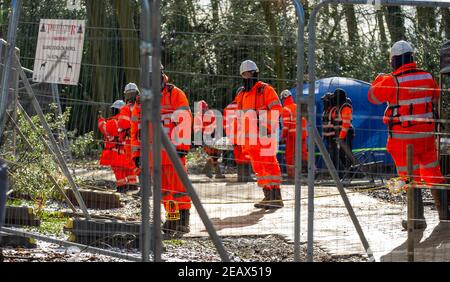 Aylesbury Vale, Buckinghamshire, Großbritannien. 10th. Februar 2021. Zahlreiche gelangweilt aussehende HS2 Sicherheit Auftragnehmer bezahlt werden, um rund um im Wald den ganzen Tag stehen. Ökologen arbeiten im Auftrag von HS2 Ltd wurden Fledermausuntersuchungen in Jones Hill Wood heute tun. Die Ökologen stellten Endoskope in potenzielle Fledermausquartiere, die alle schlafenden Fledermäuse gestört haben könnten. Sehr seltene Barbaren Fledermäuse werden geglaubt, um in diesem Wald zu brüten. HS2 plant, einen großen Teil dieses alten Waldgebietes für die umstrittene Hochgeschwindigkeitsstrecke von London nach Birmingham zu zerstören. Quelle: Maureen McLean/Alamy Live News Stockfoto