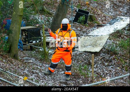 Aylesbury Vale, Buckinghamshire, Großbritannien. 10th. Februar 2021. Zahlreiche gelangweilt aussehende HS2 Sicherheit Auftragnehmer bezahlt werden, um rund um im Wald den ganzen Tag stehen. Ökologen arbeiten im Auftrag von HS2 Ltd wurden Fledermausuntersuchungen in Jones Hill Wood heute tun. Die Ökologen stellten Endoskope in potenzielle Fledermausquartiere, die alle schlafenden Fledermäuse gestört haben könnten. Sehr seltene Barbaren Fledermäuse werden geglaubt, um in diesem Wald zu brüten. HS2 plant, einen großen Teil dieses alten Waldgebietes für die umstrittene Hochgeschwindigkeitsstrecke von London nach Birmingham zu zerstören. Quelle: Maureen McLean/Alamy Live News Stockfoto