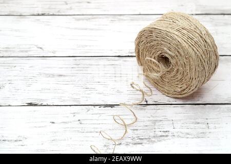 zwirn aus Leinengarn auf weißem Grunge-Holztisch Stockfoto