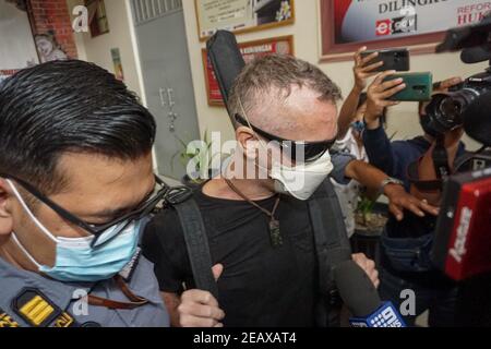 Badung, Bali, Indonesien. Februar 2021, 10th. DAVID TAYLOR (c) eskortiert von Immigration Officer. DAVID TAYLOR, auch bekannt als 'DJ NUTZO', britischer Staatsbürger, der 2016 einen Bali-Polizisten tötete WAYAN SUDIARSA, wurde nach 5 Jahren Haft im Kerobokan Gefängnis freigelassen. Seine Freundin Sara CONNOR, die beide wegen tödlichen Gruppenangriffs verurteilt wurden, wurde am 2020. Juli freigelassen. (Bild: © Dicky BisinglasiZUMA Wire) Quelle: ZUMA Press, Inc./Alamy Live News Stockfoto