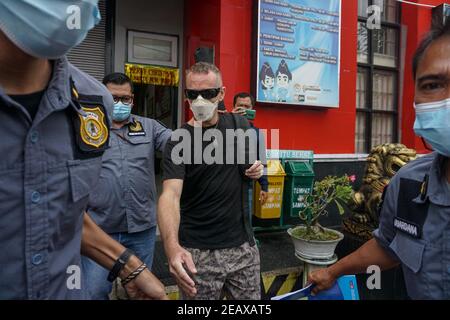 Badung, Bali, Indonesien. Februar 2021, 10th. DAVID TAYLOR (c) eskortiert von Einwanderungsbeamten. DAVID TAYLOR, auch bekannt als 'DJ NUTZO', britischer Staatsbürger, der 2016 einen Bali-Polizisten tötete WAYAN SUDIARSA, wurde nach 5 Jahren Haft im Kerobokan Gefängnis freigelassen. Seine Freundin Sara CONNOR, die beide wegen tödlichen Gruppenangriffs verurteilt wurden, wurde am 2020. Juli freigelassen. (Bild: © Dicky BisinglasiZUMA Wire) Quelle: ZUMA Press, Inc./Alamy Live News Stockfoto