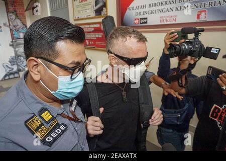 Badung, Bali, Indonesien. Februar 2021, 10th. DAVID TAYLOR (c) eskortiert von Immigration Officer. DAVID TAYLOR, auch bekannt als 'DJ NUTZO', britischer Staatsbürger, der 2016 einen Bali-Polizisten tötete WAYAN SUDIARSA, wurde nach 5 Jahren Haft im Kerobokan Gefängnis freigelassen. Seine Freundin Sara CONNOR, die beide wegen tödlichen Gruppenangriffs verurteilt wurden, wurde am 2020. Juli freigelassen. (Bild: © Dicky BisinglasiZUMA Wire) Quelle: ZUMA Press, Inc./Alamy Live News Stockfoto