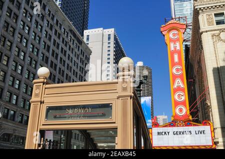 Chicago, Illinois, USA. Zwei Stadtsymbole, ein U-Bahnausgangsportal auf der State Street bei einem lokalen Wahrzeichen, dem Chicago Theatre. Stockfoto