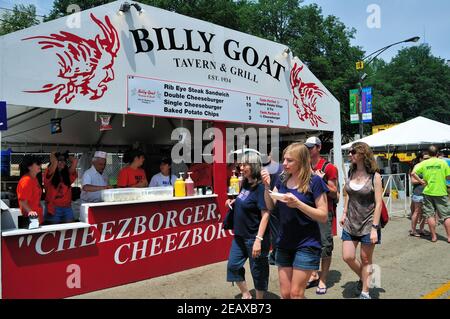 Chicago, Illinois, USA. Die Leute essen unterwegs, während sie an einem der Essensstände im Taste of Chicago, einem Sommerfestival in der Innenstadt, vorbeikommen. Stockfoto