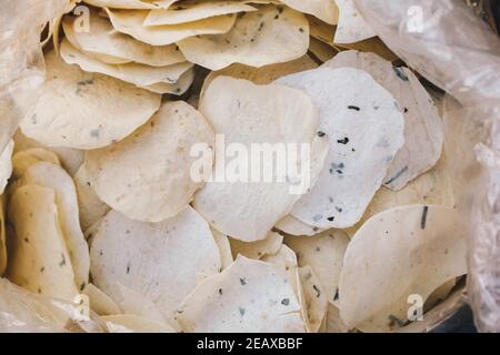 Gelbe rohe Cracker oder Kerupuk verkaufen auf dem traditionellen Markt In Indonesien Stockfoto