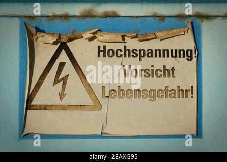 Verblichenes Schild mit der Aufschrift Hochspannung, Achtung Lebensgefahr (Hochspannung Sicht Lebensgefahr) Stockfoto