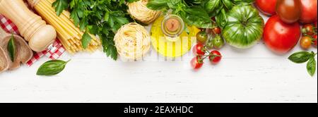 Nudeln, Tomaten und Kräuter. Kochzutaten auf Holztisch. Draufsicht flach liegend Stockfoto