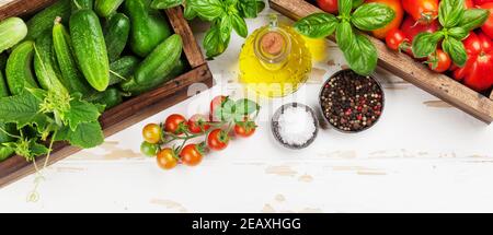 Frische Gartentomaten und Gurken mit Kräutern Kochen auf Holztisch. Draufsicht flach liegend Stockfoto