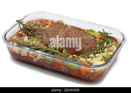Rindersteak mit Zweig Rosmarin und Gemüse in Glasschüssel Isoliert auf weißem Hintergrund Stockfoto