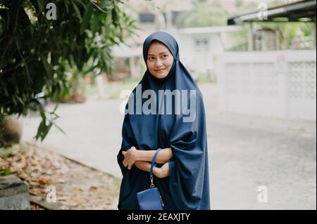 Thailändische muslimische Womam trägt ein blaues Hijab-Kleid und lächelt. Stockfoto