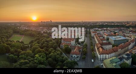 Die herrliche Aussicht auf München in bayern von einer Drohne, eine Panoramaantenne über einen Park, Häuser bei der Frühsommer Sonnenaufgang in der Mitte der Stockfoto