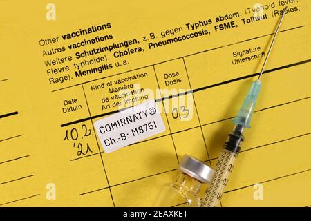 Impfzertifikat mit Pfizer-BioNTech COVID-19 Impfstoff Comirnaty mit Spritze Und Fläschchen Stockfoto