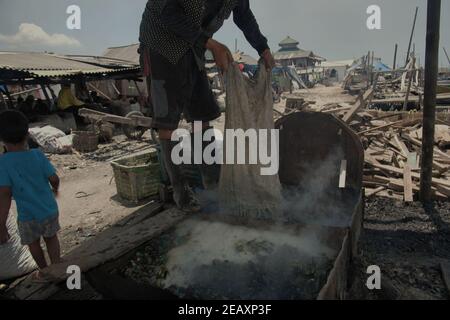 Ein Arbeiter kocht grüne Muscheln in einem Produktionsgebiet in Kamal Muara, Jakarta, Indonesien. Stockfoto