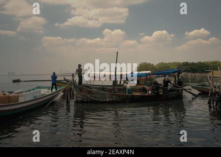 Fischer auf Booten auf dem Küstenwasser von Kamal Muara, einem Fischerdorf, das auch als grünes Muschelproduktionsgebiet an der Küste von Jakarta, Indonesien, bekannt ist. Stockfoto