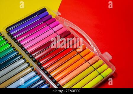 Großer Satz von bunten Filzstiften zum Zeichnen auf einem farbigen Hintergrund. Kunststoffbox mit Markern in verschiedenen Farben und Schattierungen. Selektiver Fokus. Stockfoto
