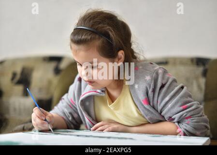 Kind Mädchen von 9 Jahren zeichnet ein Bild mit Farben zu Hause Stockfoto