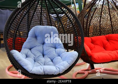 Gartenkorbmöbel. Hängende Schaukel mit blauem weichen Kissen. Schöne, moderne Möbel, Rattan Sofa, Sitz Stockfoto