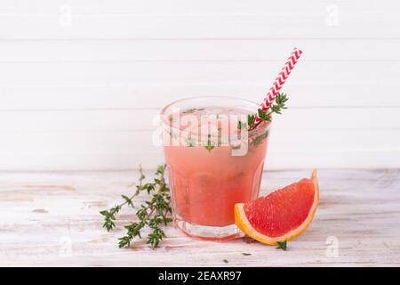 Gesunder Sommertrunk Grapefruitlimonade mit Thymian in Gläsern mit Eis auf der hölzernen Oberfläche, horizontal Stockfoto