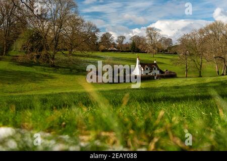 Sonnige winterliche Landschaft der Chiltern Hills mit einem kleinen Häuschen zwischen Hügeln, England Stockfoto