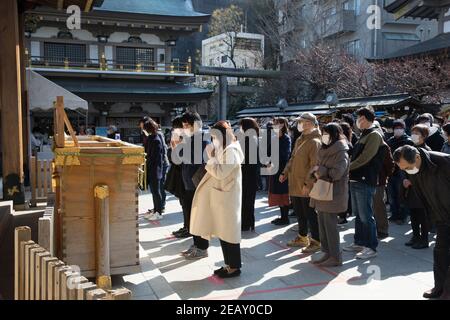 Tokio, Japan. Februar 2021, 11th. Besucher tragen Gesichtsmasken als vorbeugende Maßnahme gegen Covid19 beten für Glück im Yushima-Schrein am japanischen Nationalfeiertag. Kredit: SOPA Images Limited/Alamy Live Nachrichten Stockfoto