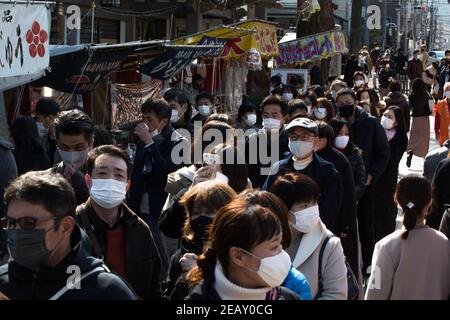 Tokio, Japan. Februar 2021, 11th. Besucher mit Gesichtsmasken als vorbeugende Maßnahme gegen Covid19 warten in der Schlange, um am Yushima-Schrein in Tokio am Tag der japanischen Nationalstiftung zu beten. Kredit: SOPA Images Limited/Alamy Live Nachrichten Stockfoto