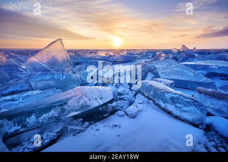 Schöne Landschaft von Eis Hummock mit Lichtreflexe des Sonnenuntergangs am Eis des Baikalsees, Russland Stockfoto