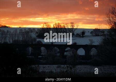 Seaton, Rutland, Großbritannien. 11th. Februar 2021. Wetter in Großbritannien. Die Sonne geht hinter dem Viadukt des Welland Valley auf, als die Temperatur in Großbritannien auf den niedrigsten Stand seit einem Jahrzehnt gesunken ist. Credit Darren Staples/Alamy Live News. Stockfoto