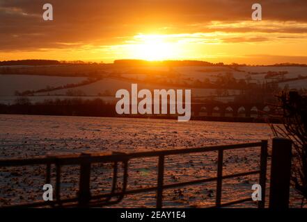 Seaton, Rutland, Großbritannien. 11th. Februar 2021. Wetter in Großbritannien. Die Sonne geht hinter dem Viadukt des Welland Valley auf, als die Temperatur in Großbritannien auf den niedrigsten Stand seit einem Jahrzehnt gesunken ist. Credit Darren Staples/Alamy Live News. Stockfoto