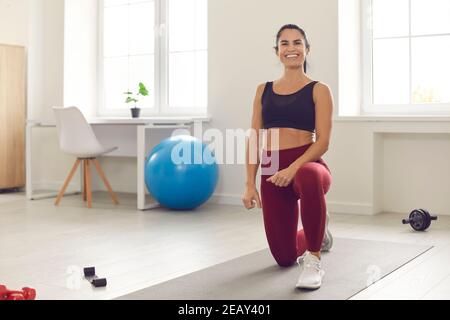 Fröhlich fit junge Frau in Sportbekleidung genießen aktive Fitness-Workout Zu Hause Stockfoto