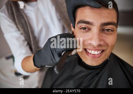 Schöner Mann mit schönen Lächeln wegschauen, während posiert an Die Fotokamera im Schönheitssalon Stockfoto