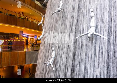 DUBAI, VAE, 26. OKTOBER 2016: Blick auf einen künstlichen Wasserfall mit Statuen von Tauchern in der Dubai Mall in den VAE. Stockfoto