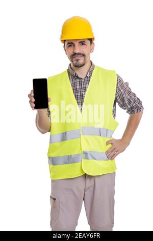 Inhalt männliche Auftragnehmer trägt Hardhut und gelbe reflektierende Weste stehen Mit Mobiltelefon auf weißem Hintergrund und Blick auf die Kamera Stockfoto