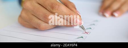 Frau füllt den Fragebogen aus, indem sie das Dokument ankreuzen. Stockfoto