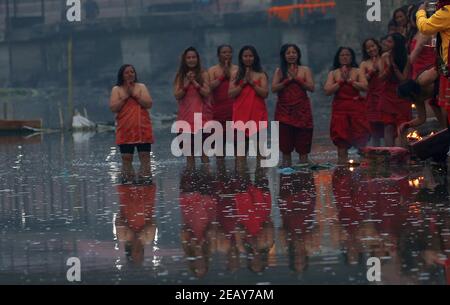 Kathmandu, Bagmati, Nepal. Februar 2021, 11th. Nepalesische Frauen bereiten sich auf das heilige Bad am Ufer des Bagmati Flusses während des Madhav Narayan Festivals im Pashupatinath Tempel in Kathmandu, Nepal am 11. Februar 2021 vor. Das einmonatige Fest soll das Fasten beobachten und zur Göttin Swasthani und zum Gott Madhav Narayan für Wohlstand der Familienmitglieder beten. Quelle: Sunil Sharma/ZUMA Wire/Alamy Live News Stockfoto