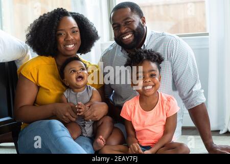 Afroamerikanische Mutter und Vater küssen und umarmen ihren Sohn. Stockfoto