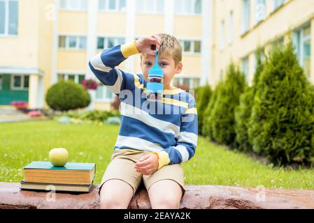 Schuljunge beim Schulessen auf dem Schulhof. Gesundes Schulfrühstück für Kinder.frisches Obst, gesundes Essen Stockfoto