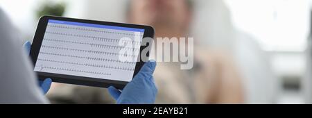 Arzt mit ekg-Monitor steht vor dem Patienten in Hintergrund Stockfoto