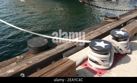 Geknotet auf metallischem Poller mit Sternen, Seefahrernhafen von San Diego, Kalifornien. Seeschiff im Dock vertäut. Kabelbinder am Span befestigt. Symbol Stockfoto