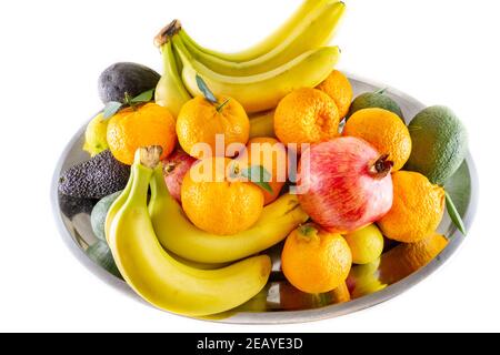 Verschiedene frische Obst- und Gemüseteller mit Bananen, Granatapfel, Zitrone, Mandarine und Avocado. Stockfoto