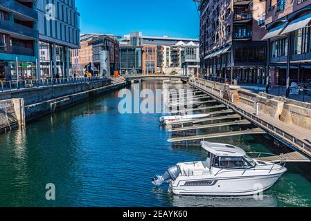 OSLO, NORWEGEN, 15. APRIL 2019: Motorboote, die in einem Kanal zwischen Wohngebäuden bei Aker Brygge, Oslo, Norwegen, festmachen Stockfoto