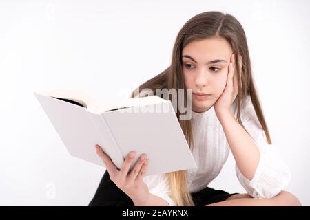 Schöne junge Dame, die ein Buch mit schwarzem Rock liest Und weiße Bluse Stockfoto