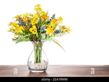 Künstliche Blumen in einer Glasvase mit einem schlichten weißen Hintergrund. Stockfoto