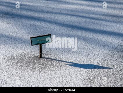 Teichpflanze Namensschild auf einem gefrorenen Teich mit weißem Eis und Schnee. Stockfoto