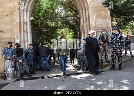 Beirut, Libanon, 11. Februar 2021. Ein schiitischer Geistlicher, der während einer Gedenkstätte sprach, die in Erinnerung an Lokman Slim gehalten wird, geht am Eingang der Veranstaltung an bewaffneter Sicherheit vorbei. Slim, ein libanesischer Verleger, politischer Aktivist und Kommentator, wurde am 4. Februar 2021 angegriffen. Elizabeth Fitt Kredit: Elizabeth Fitt/Alamy Live News Stockfoto