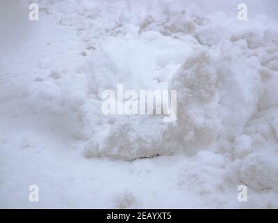 Große Stücke von gefrorenem Schnee auf der Seite der Straße. Stockfoto