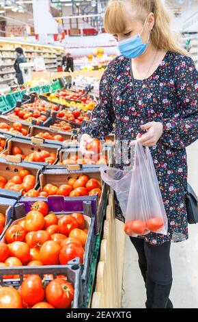 Eine Frau wählt Tomaten in einem Supermarkt. Selektiver Fokus. Essen. Stockfoto