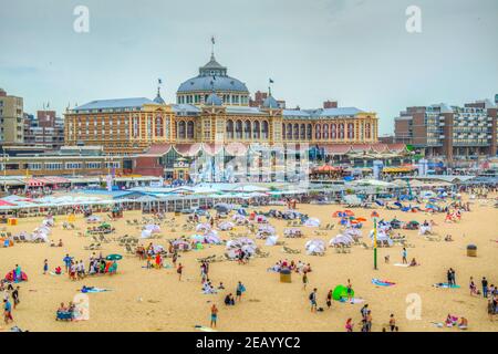 DEN HAAG, NIEDERLANDE, 7. AUGUST 2018: Kurhaus in Scheveningen hinter einem Strand voller Menschen, Niederlande Stockfoto