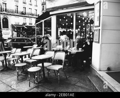 PARIS, FRANKREICH - 14. FEBRUAR 2019: Menschen und Teddybären sitzen auf der Terrasse und im Café im Quartier Latin, das zum Valentinstag dekoriert ist. Schwarz-weiß Stockfoto