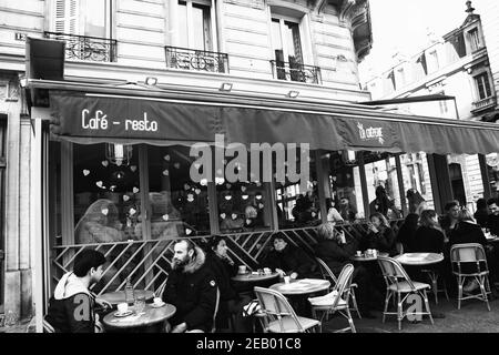 PARIS, FRANKREICH - 14. FEBRUAR 2019: Menschen und Teddybären sitzen auf der Terrasse und im Café im Quartier Latin, das zum Valentinstag dekoriert ist. Schwarz-weiß Stockfoto